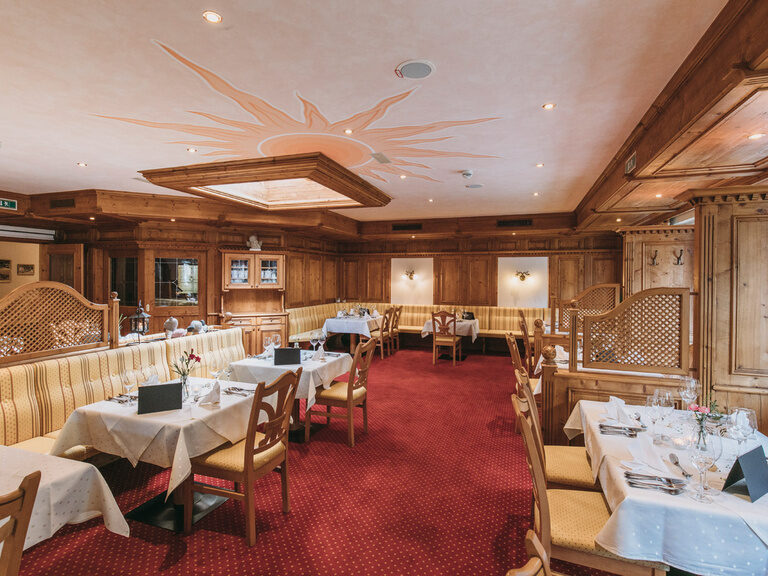 Ein elegantes Restaurantdesign mit Holzmöbeln und blumengeschmückten Tischen im Hotel Hirschen.
