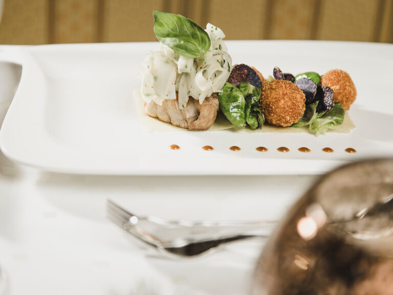 Auf einem weißen Teller wurde mit viel Gefühl ein leckeres Dessert kreiert.